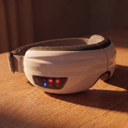 The Velto Heated Eye Massager with its controls lit, in warm evening light