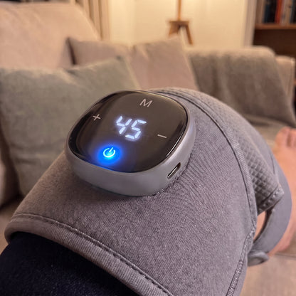 The Velto Heated Knee Massager switched on at the knee, showing the warmth setting