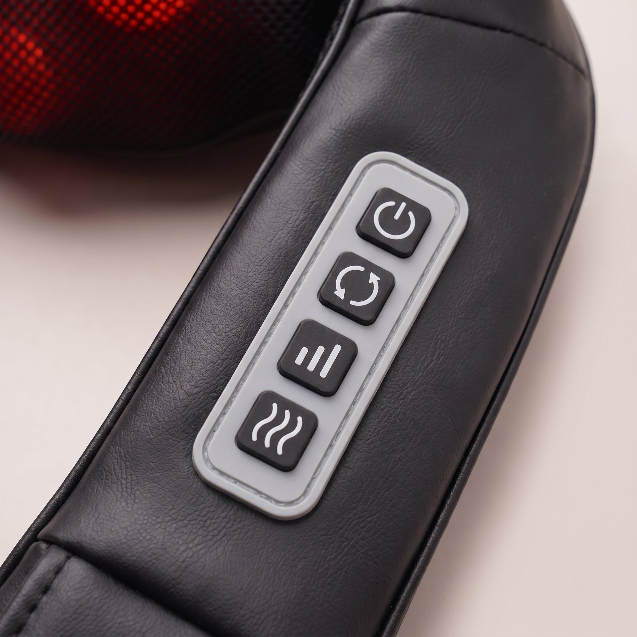 Close-up of the Velto Neck & Shoulder Massager's four-button control panel on the strap